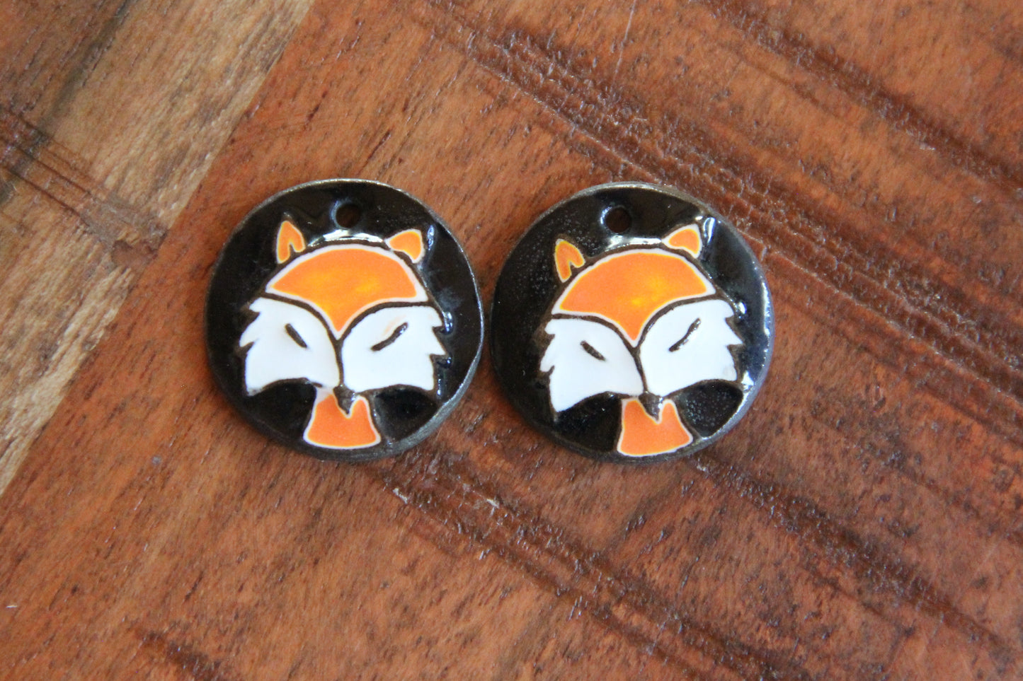 A pair of ceramic earring dangles with foxes