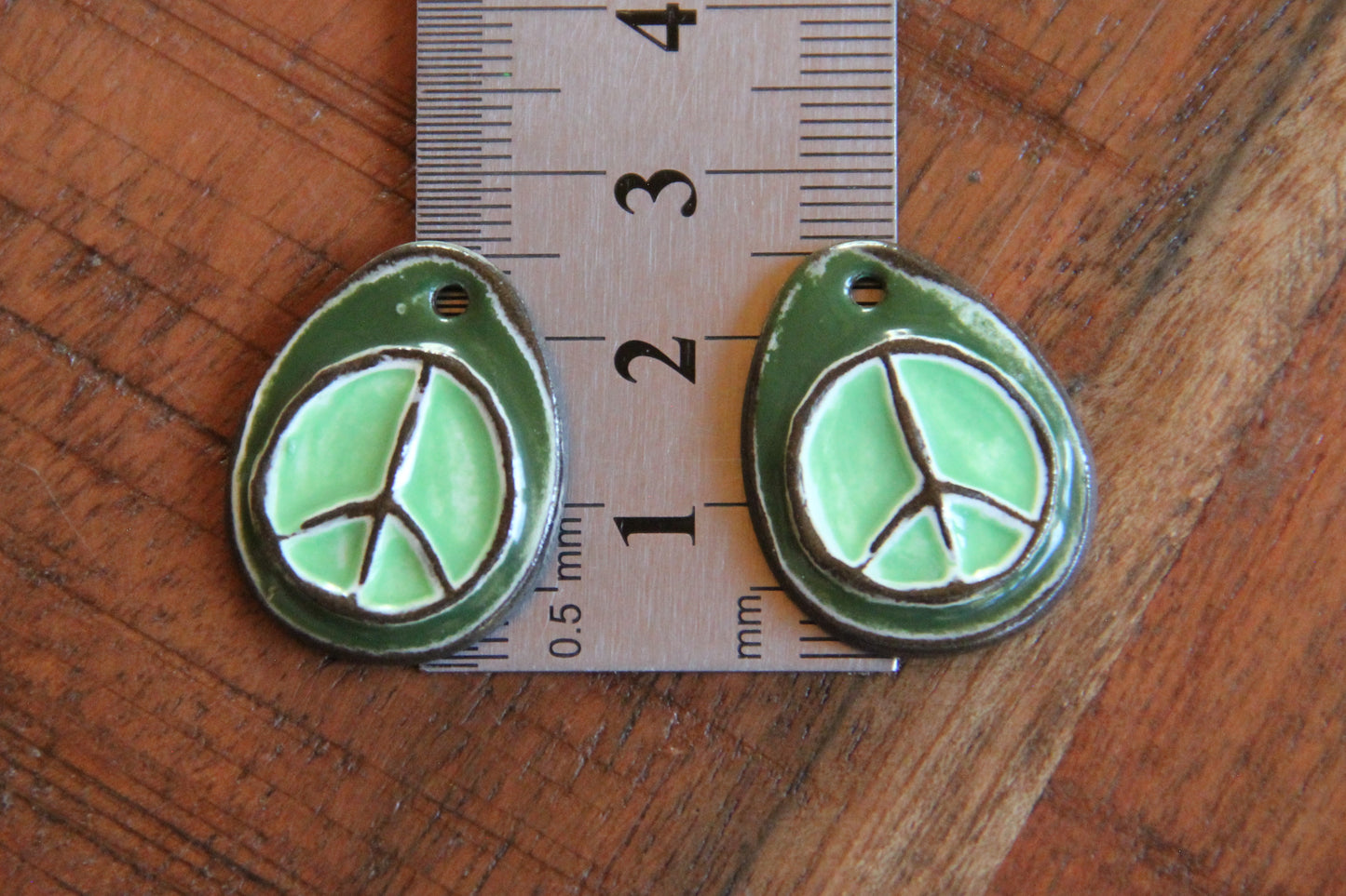 A pair of PEACE ceramic earring dangles