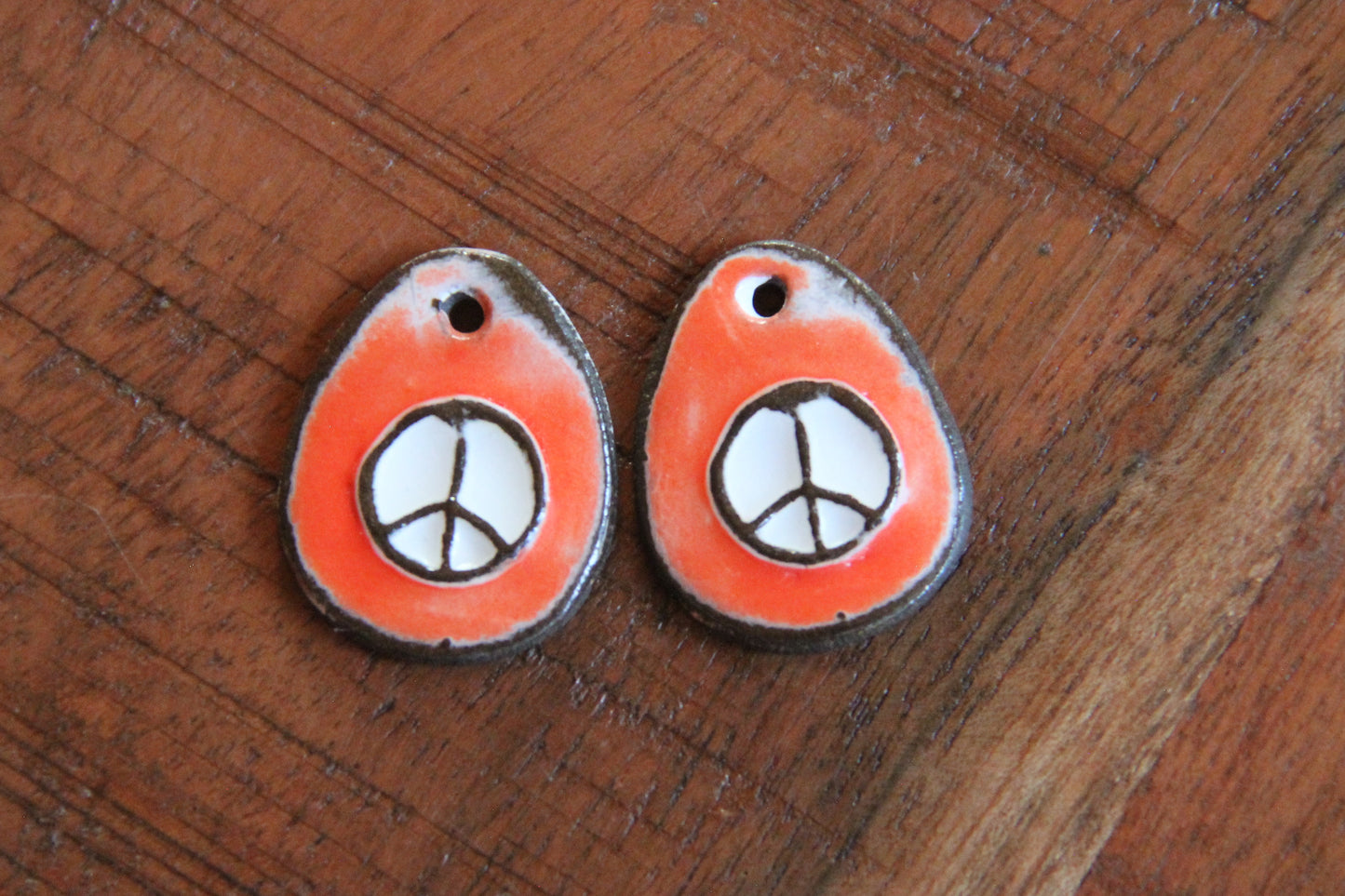 A pair of PEACE ceramic earring dangles