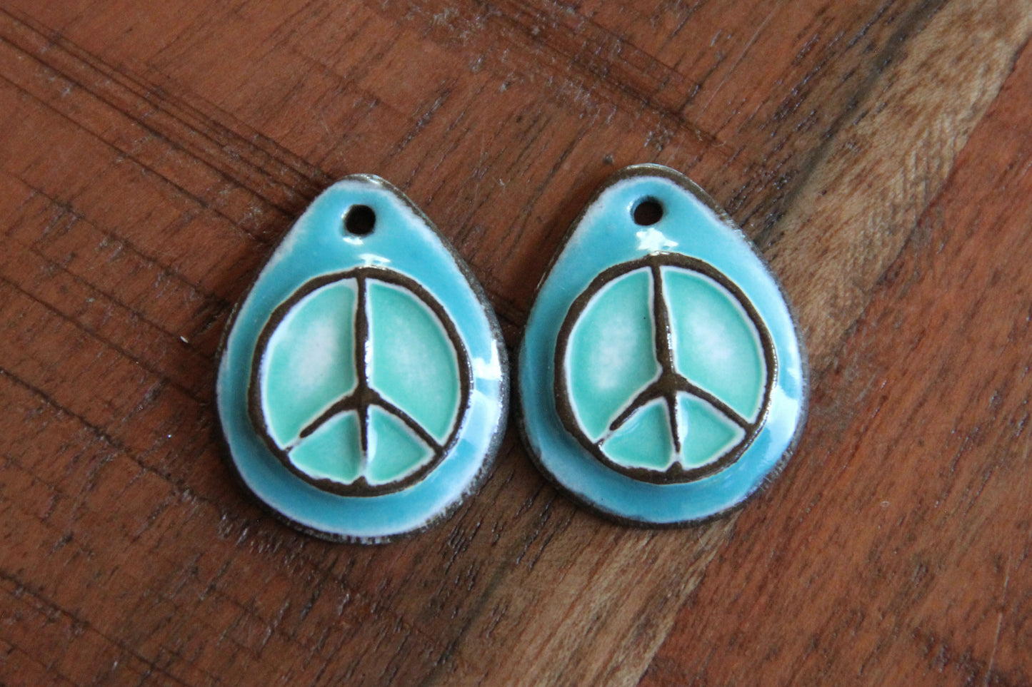A pair of PEACE ceramic earring dangles