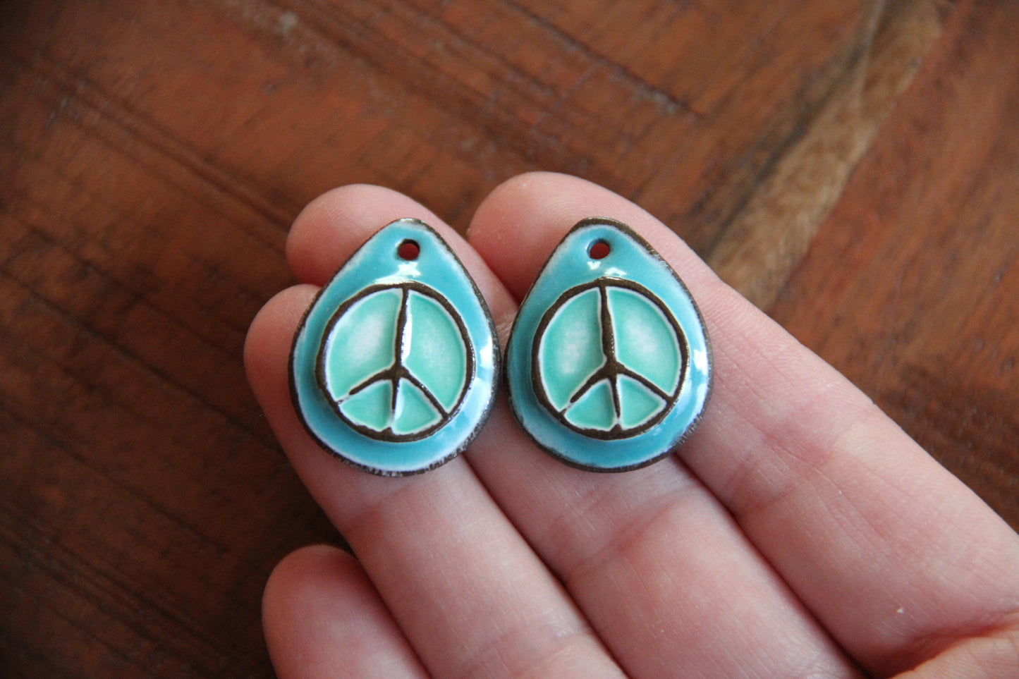 A pair of PEACE ceramic earring dangles