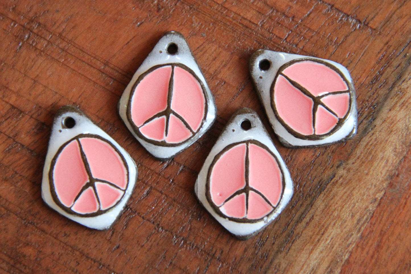 A pair of PEACE ceramic earring dangles