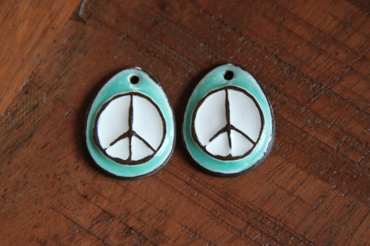 A pair of PEACE ceramic earring dangles