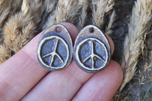 A pair of PEACE ceramic earring dangles