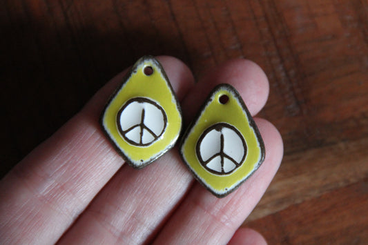 A pair of PEACE ceramic earring dangles