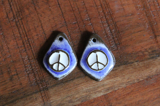 A pair of PEACE ceramic earring dangles