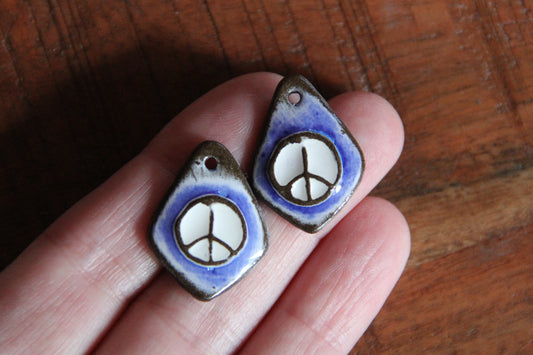 A pair of PEACE ceramic earring dangles