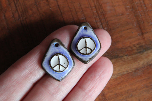A pair of PEACE ceramic earring dangles