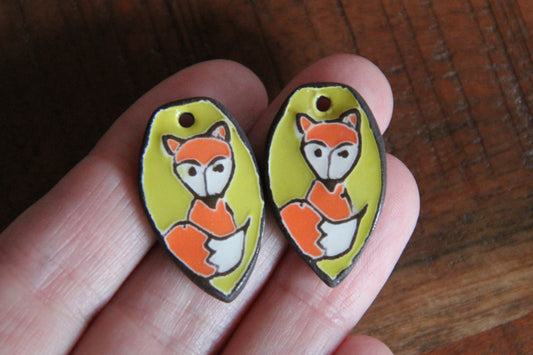 A pair of ceramic earring dangles with foxes