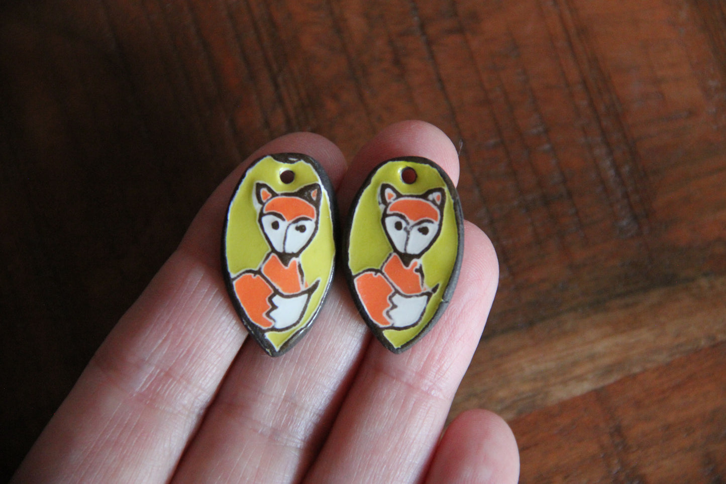 A pair of ceramic earring dangles with foxes
