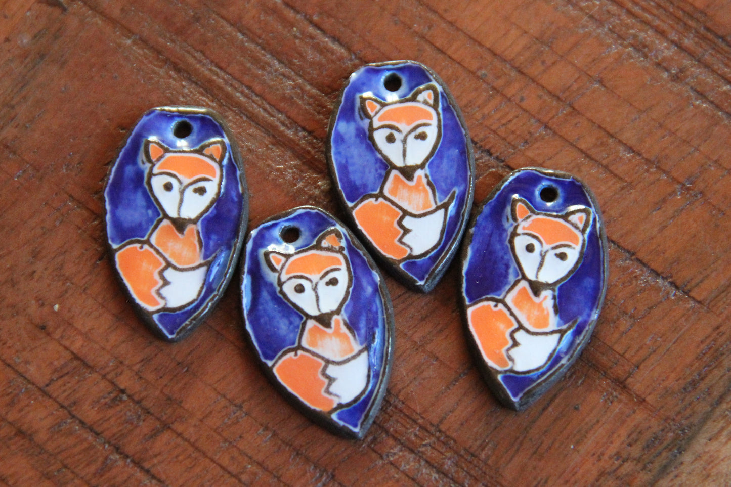 A pair of ceramic earring dangles with foxes