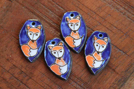 A pair of ceramic earring dangles with foxes