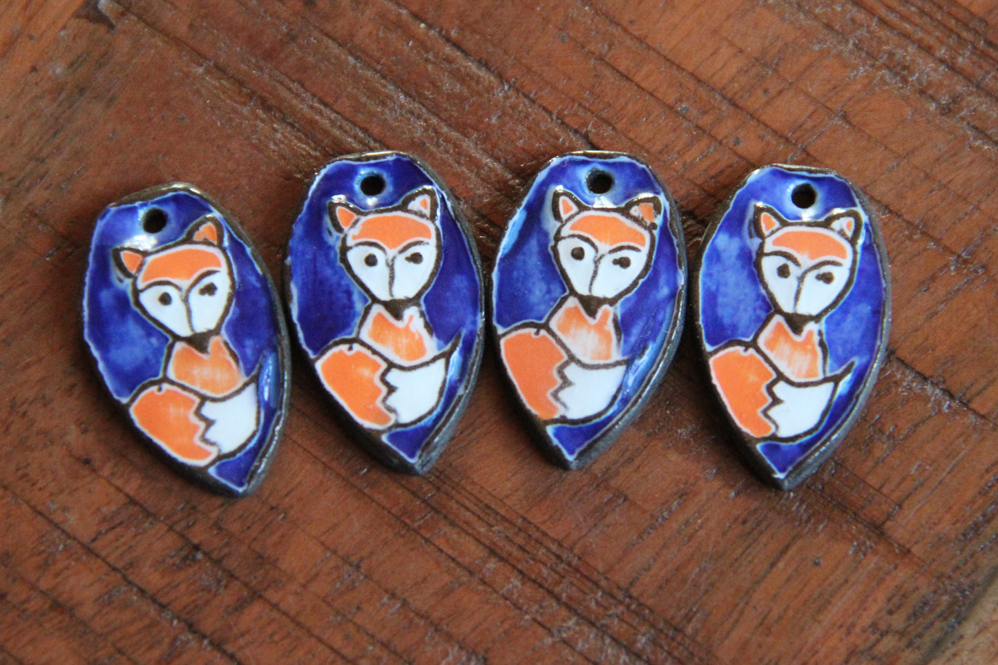 A pair of ceramic earring dangles with foxes