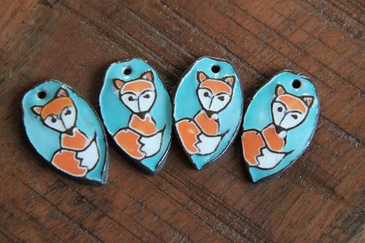 A pair of ceramic earring dangles with foxes