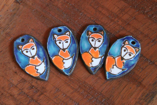 A pair of ceramic earring dangles with foxes
