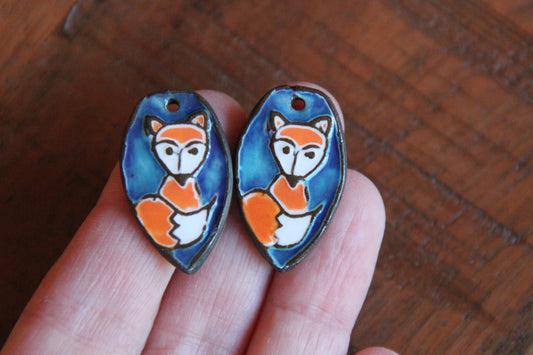A pair of ceramic earring dangles with foxes