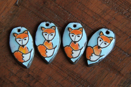 A pair of ceramic earring dangles with foxes