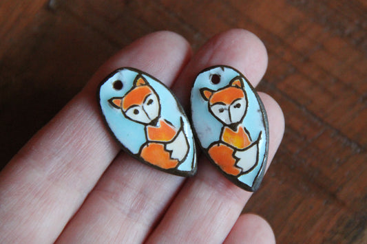 A pair of ceramic earring dangles with foxes