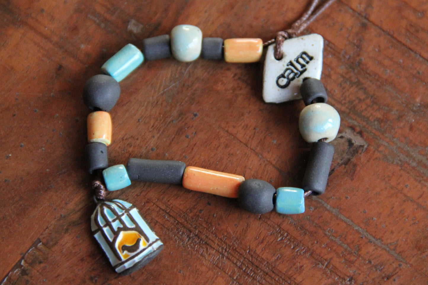 CALM - Bracelet set with a charm BIRD WITH CAGE DOOR OPENED