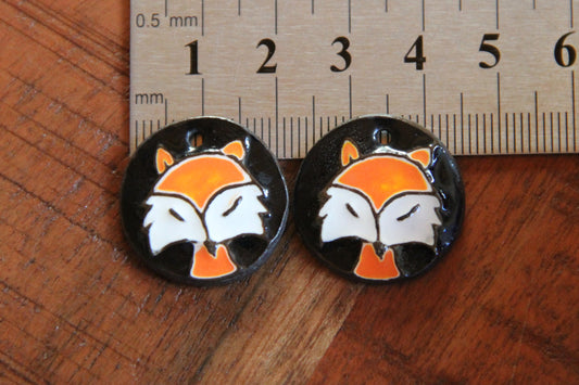 A pair of ceramic earring dangles with foxes