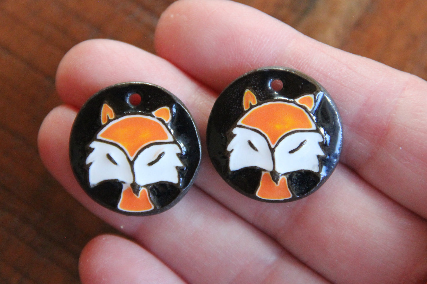 A pair of ceramic earring dangles with foxes