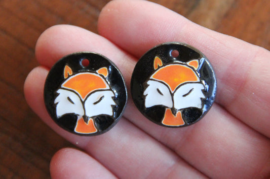 A pair of ceramic earring dangles with foxes