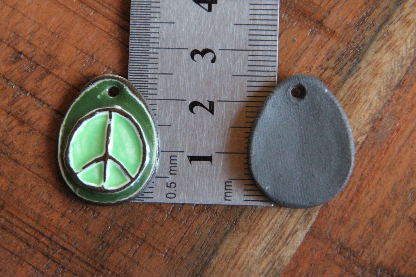 A pair of PEACE ceramic earring dangles