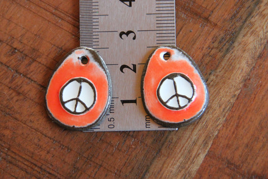 A pair of PEACE ceramic earring dangles