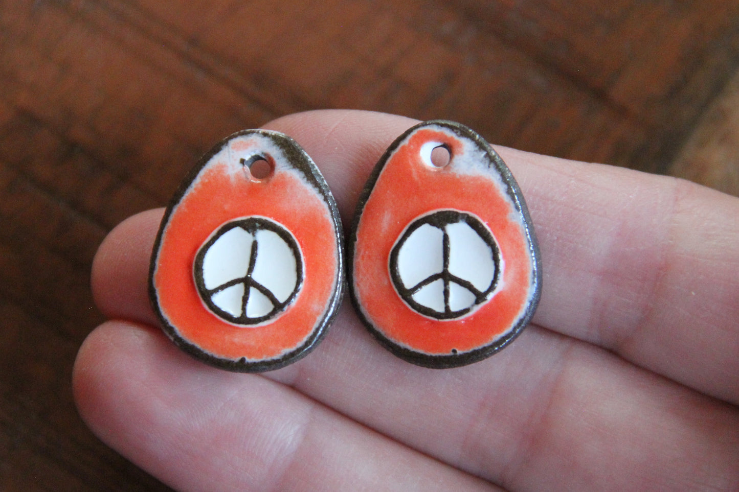 A pair of PEACE ceramic earring dangles