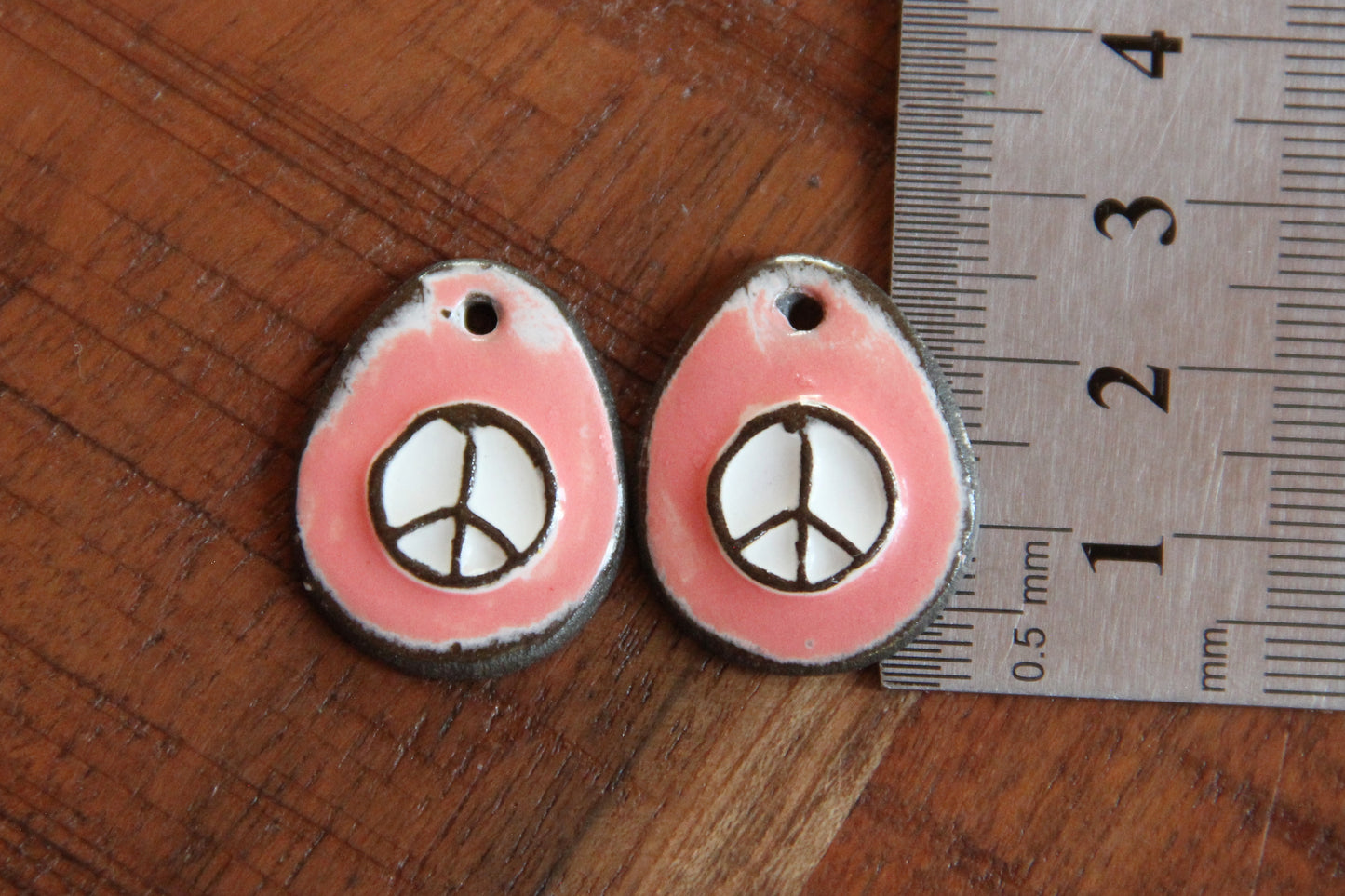 A pair of PEACE ceramic earring dangles