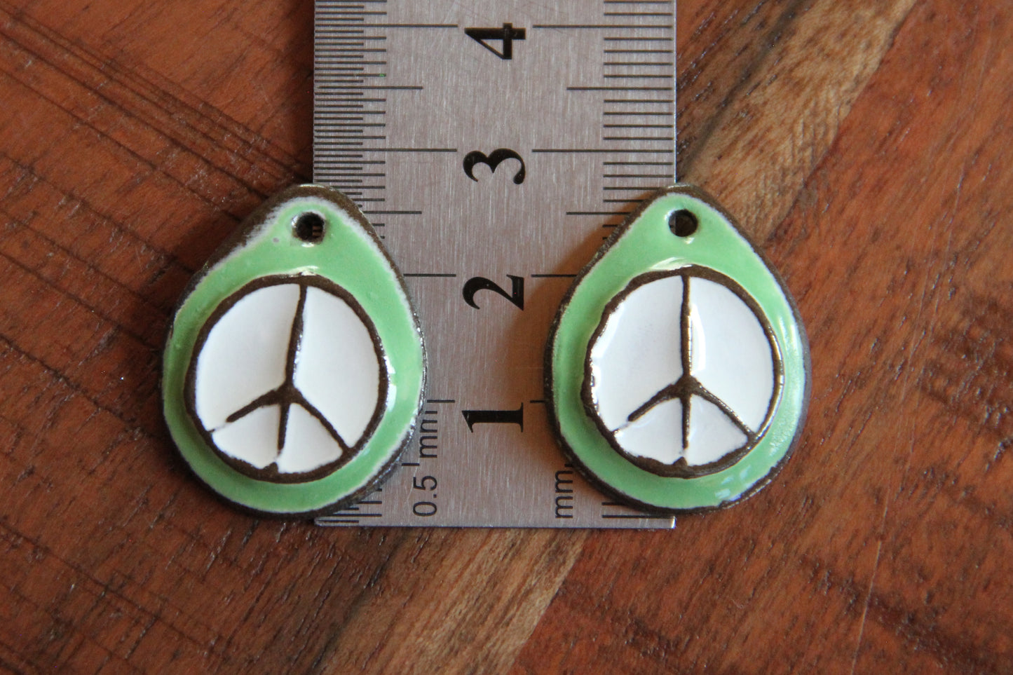 A pair of PEACE ceramic earring dangles