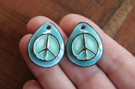 A pair of PEACE ceramic earring dangles