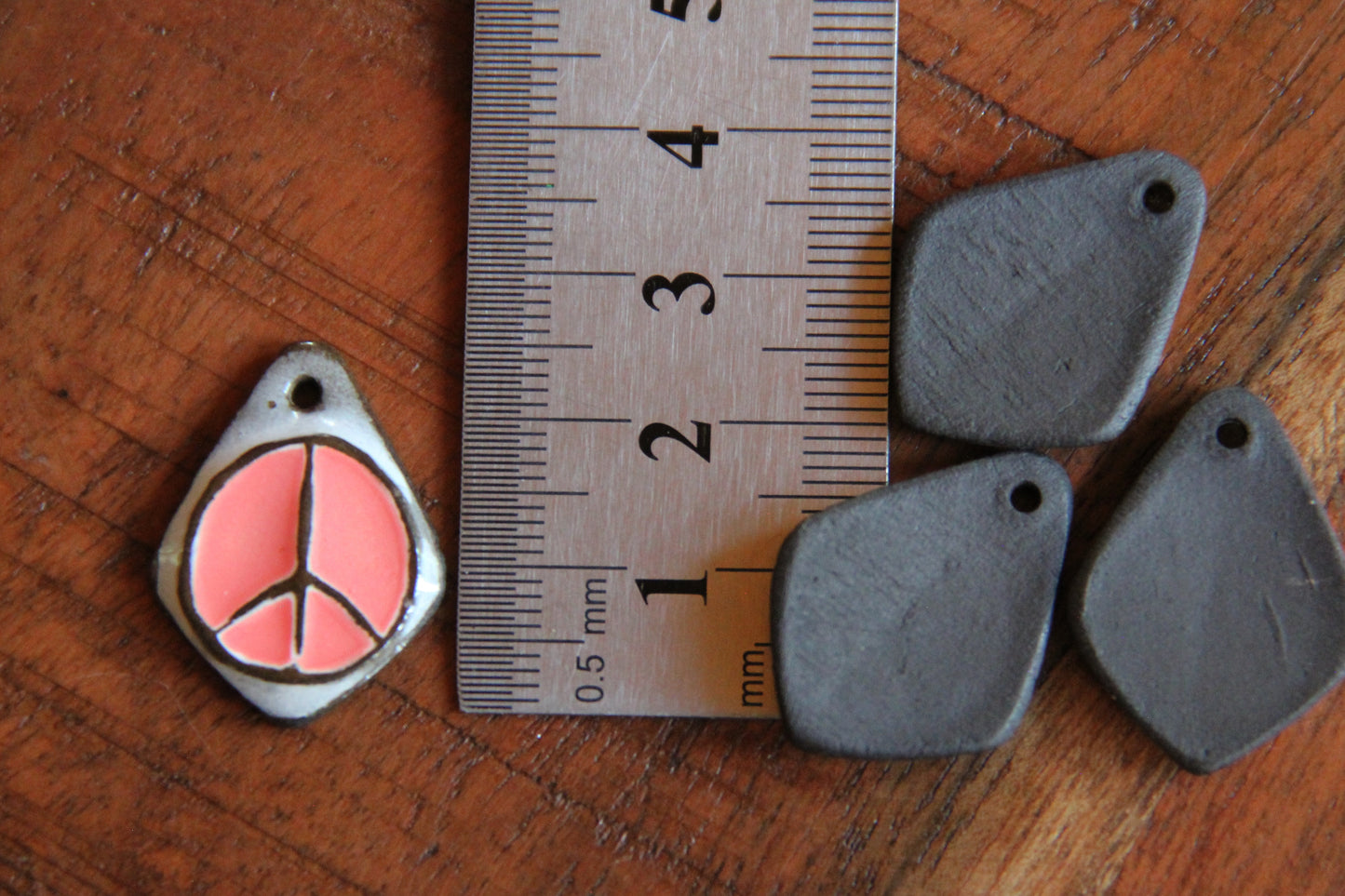A pair of PEACE ceramic earring dangles