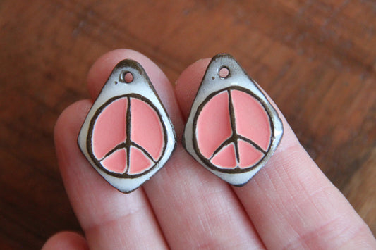 A pair of PEACE ceramic earring dangles