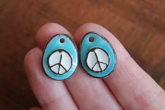 A pair of PEACE ceramic earring dangles