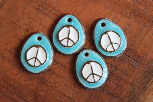A pair of PEACE ceramic earring dangles