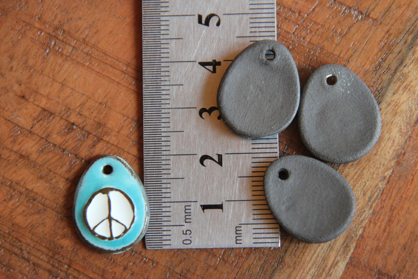 A pair of PEACE ceramic earring dangles
