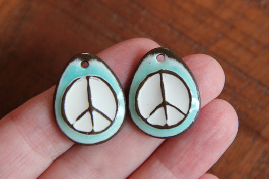 A pair of PEACE ceramic earring dangles
