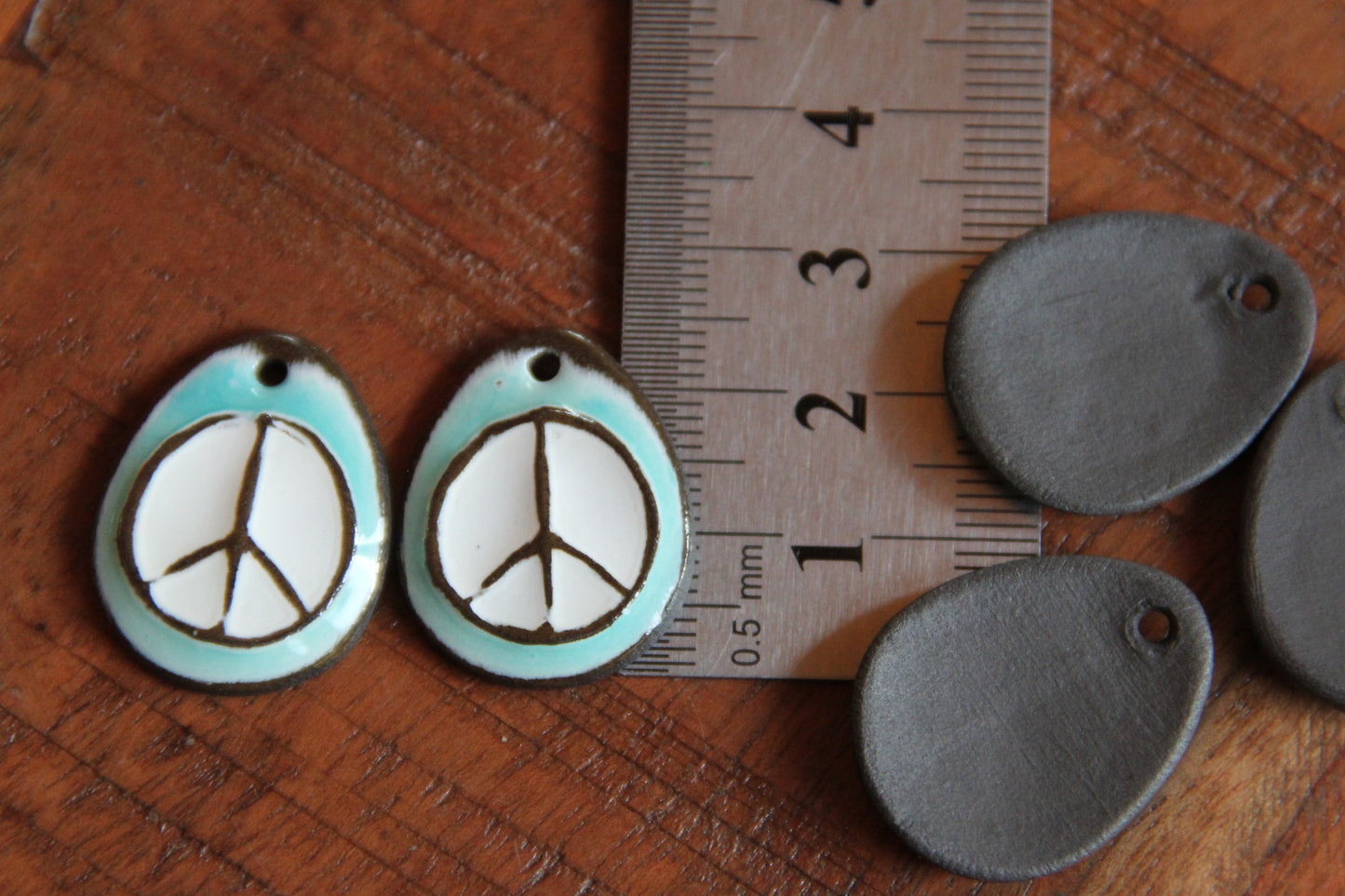 A pair of PEACE ceramic earring dangles