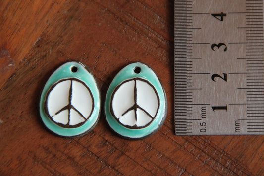 A pair of PEACE ceramic earring dangles