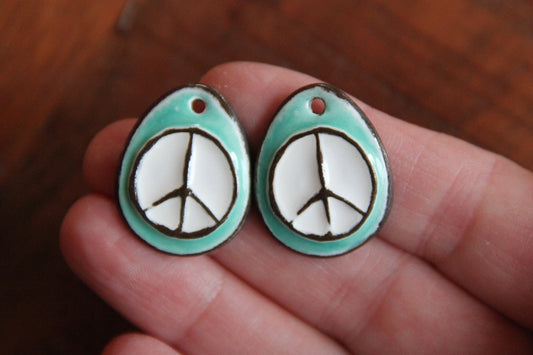 A pair of PEACE ceramic earring dangles