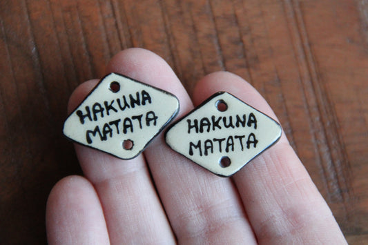 A pair of ceramic CONNECTORS hakuna matata
