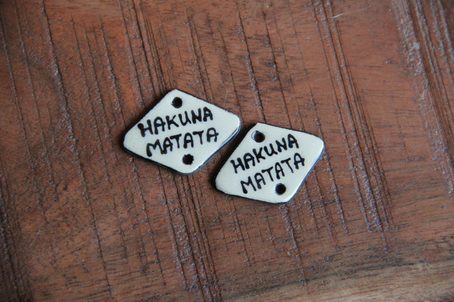 A pair of ceramic CONNECTORS hakuna matata