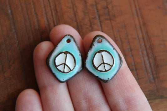 A pair of PEACE ceramic earring dangles