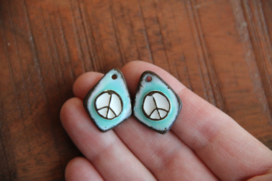 A pair of PEACE ceramic earring dangles
