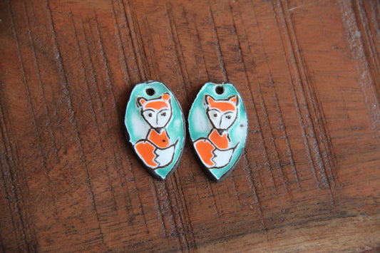 A pair of ceramic earring dangles with foxes