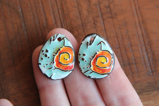 A pair of ceramic earring dangles with SPIRAL