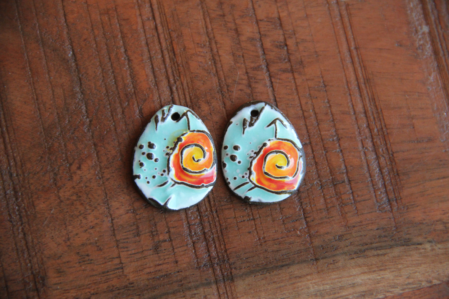 A pair of ceramic earring dangles with SPIRAL
