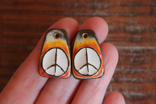 A pair of PEACE ceramic earring dangles