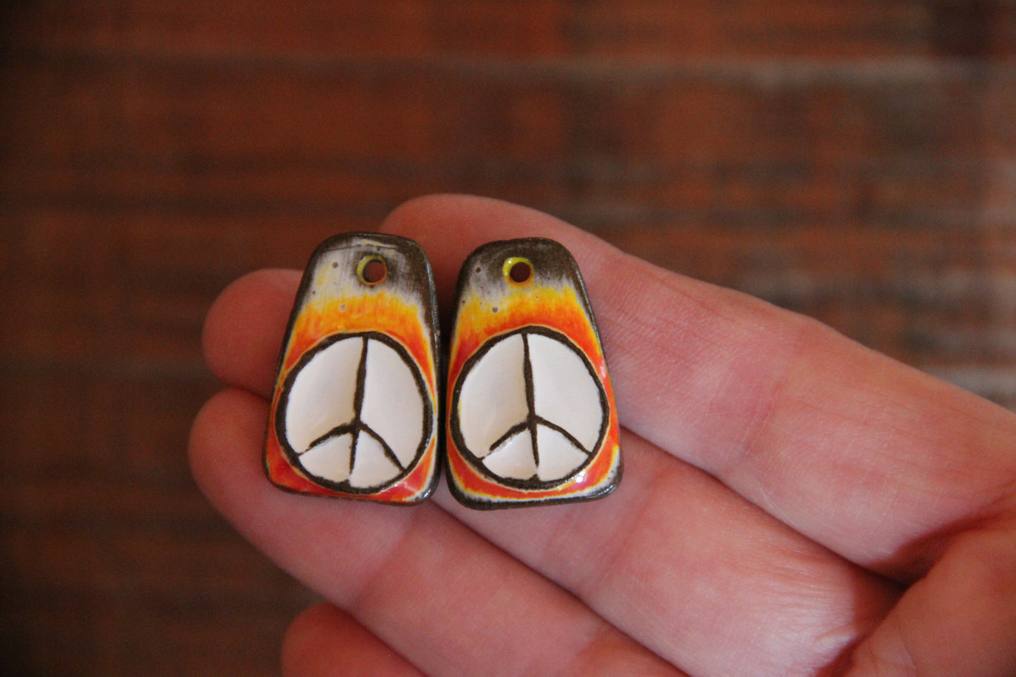 A pair of PEACE ceramic earring dangles
